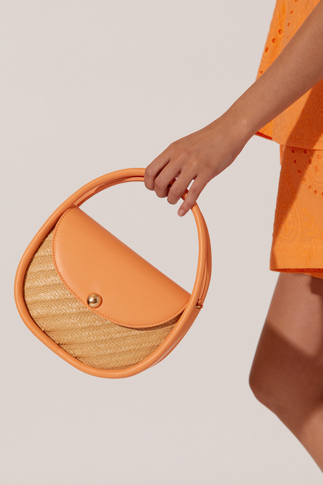 ADORNE VIOLETTA WOVEN CIRCULAR MINI BAG IN MANDARIN
